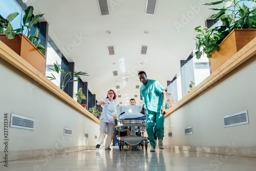 Medics running with bed in hospital