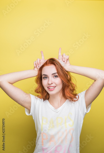Studio Portrait Of Beautiful Redhead Girl Against The Yellow Background