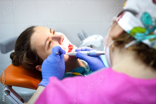 Dentist treats patient's teeth in dental clinic.