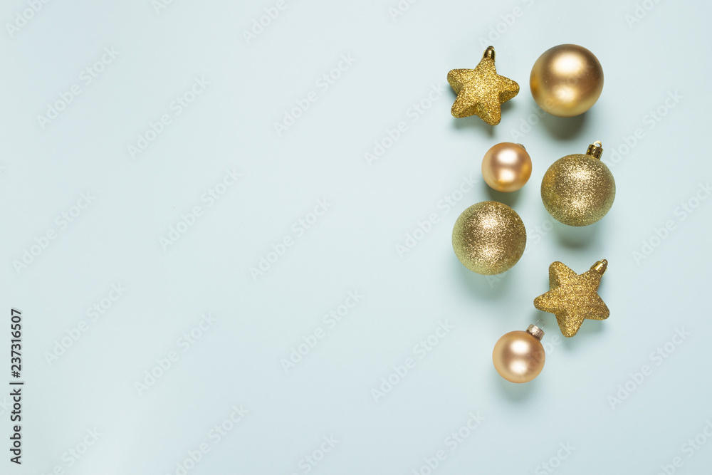 Golden holiday toys on a blue background. Place for text and design. Copy space. Flat layout Christmas or New Year concept. Golden holiday toys on a blue background. Place for text and design. Copy space. Flat layout Christmas or New Year concept.