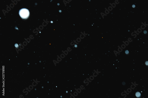 Flakes of snow falling on a black background. Isolated