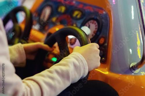 Girl's hand with a toy Steering wheel on the slot machine. Close-up.