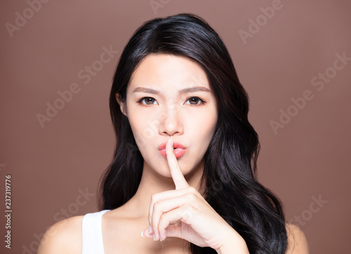young woman with natural makeup and silent gesture
