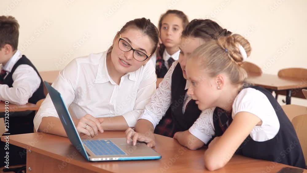 Teacher discussing a computer program with a group of pupils Teacher discussing a computer program with a group of pupils