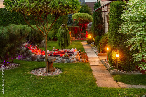 Garden illuminated by lamps in evening
