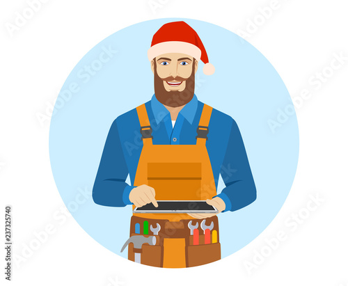 Worker in Santa hat uses digital tablet PC.