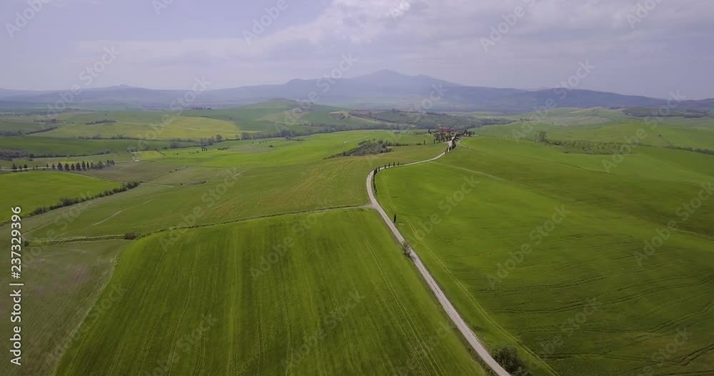 Aerial, beautiful green hills and fields and cypresses landscape in Val d’Orcia in Tuscany, Italy Aerial, beautiful green hills and fields and cypresses landscape in Val d’Orcia in Tuscany, Italy