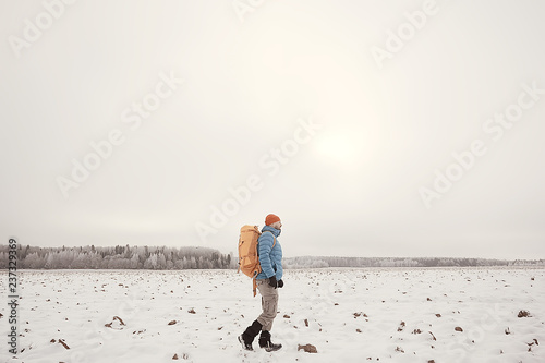 tourist view from the back / a man with a backpack goes through the winter forest, view of the outgoing