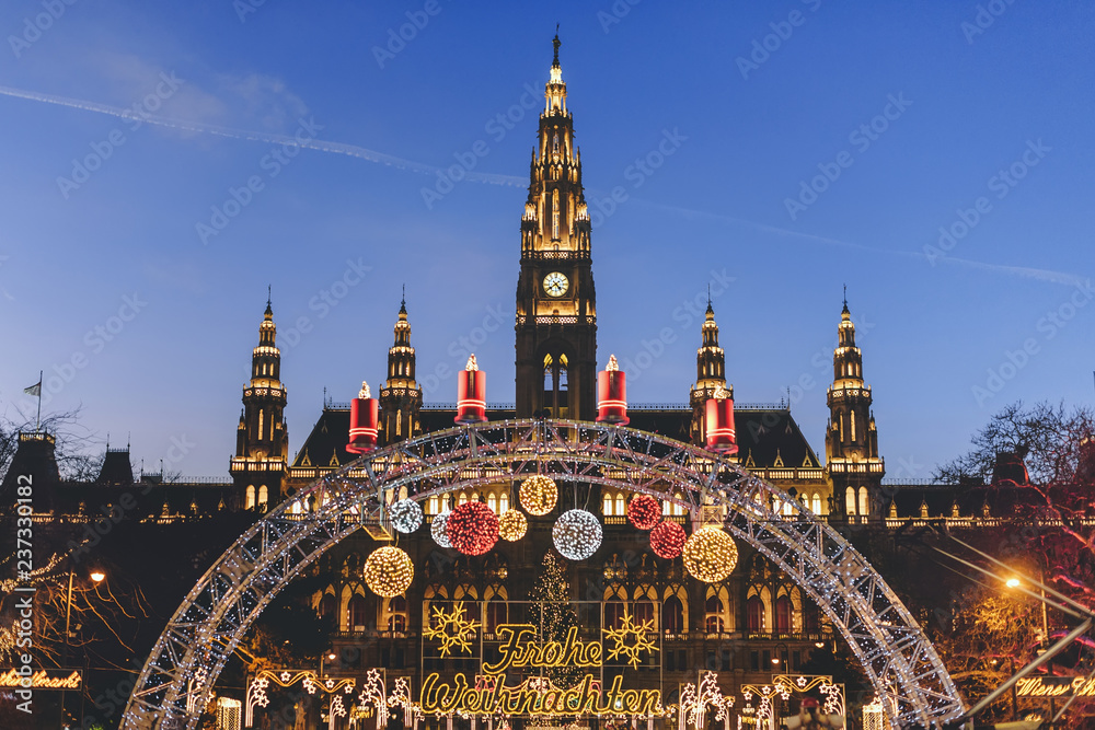 Vienna, Austria - December 24, 2017. Traditional Christmas market in front of the Rathaus City hall of Vienna. Xmas fair decorated with lights and Viennese town-hall on the Rathausplatz square.