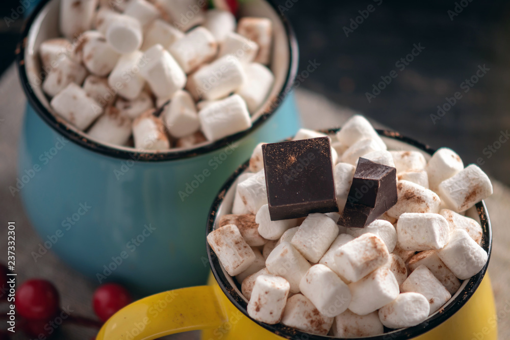 Mug of hot chocolate with marshmallow on top and Lollipop stick on dark wooden background. Cozy warm winter composition Mug of hot chocolate with marshmallow on top and Lollipop stick on dark wooden background. Cozy warm winter composition