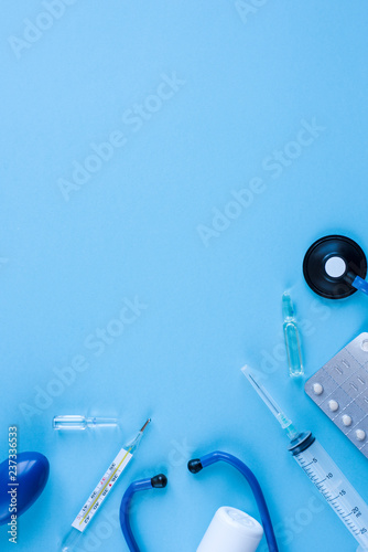 Different medical equipment on blue background. The view from the top.