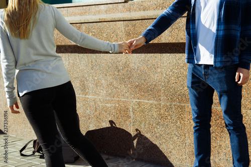 couple holding hands on the street, parting, let go of the man's hand. let go of love parting