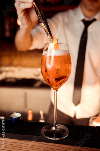 hands of the barman who poured apelol into glasses