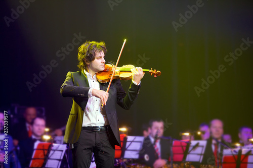 Musician violinist with a violin in his hands.