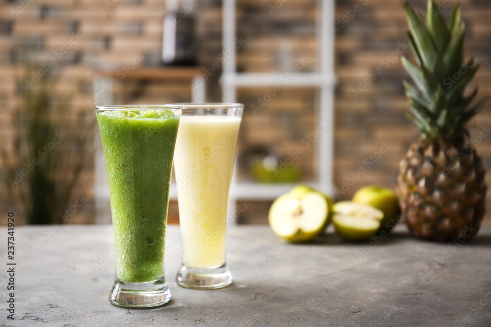 Glasses of tasty smoothies on grey table Glasses of tasty smoothies on grey table