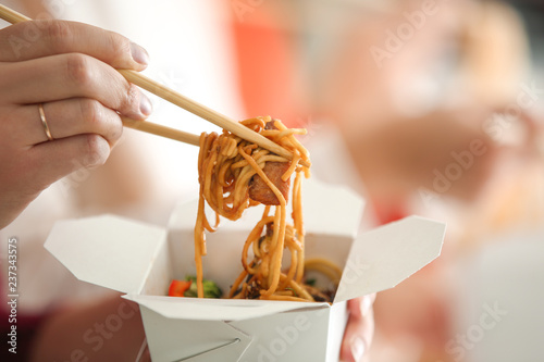 Fotografie Woman eating chinese noodles from takeaway box, closeup