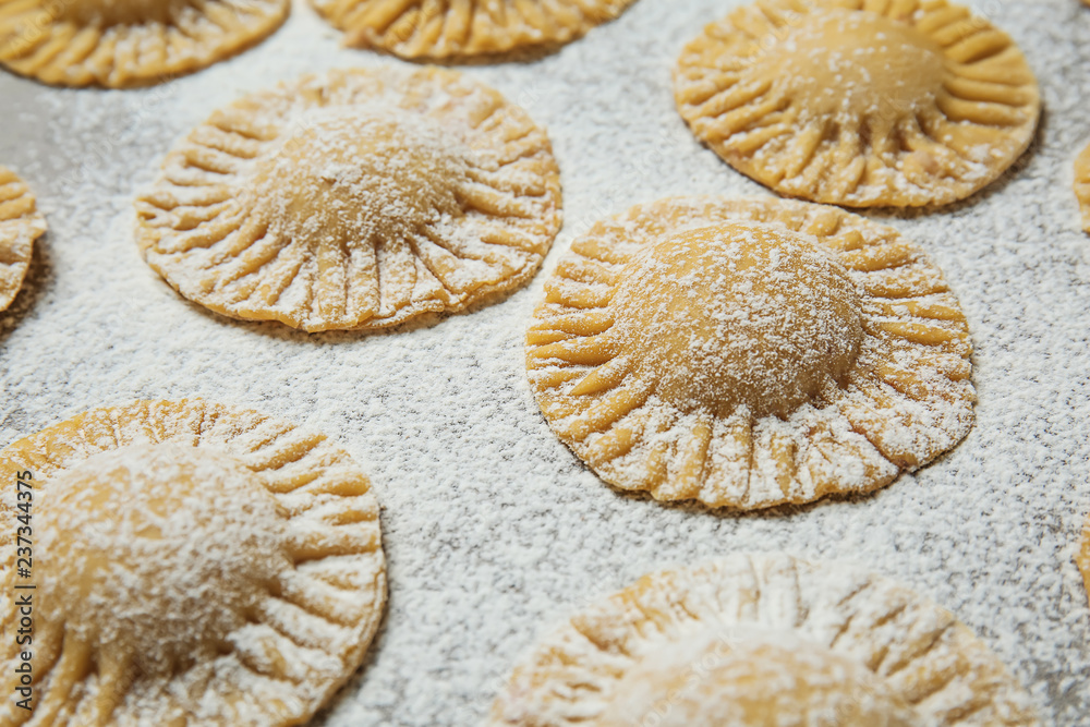 Raw ravioli on kitchen table, closeup Raw ravioli on kitchen table, closeup