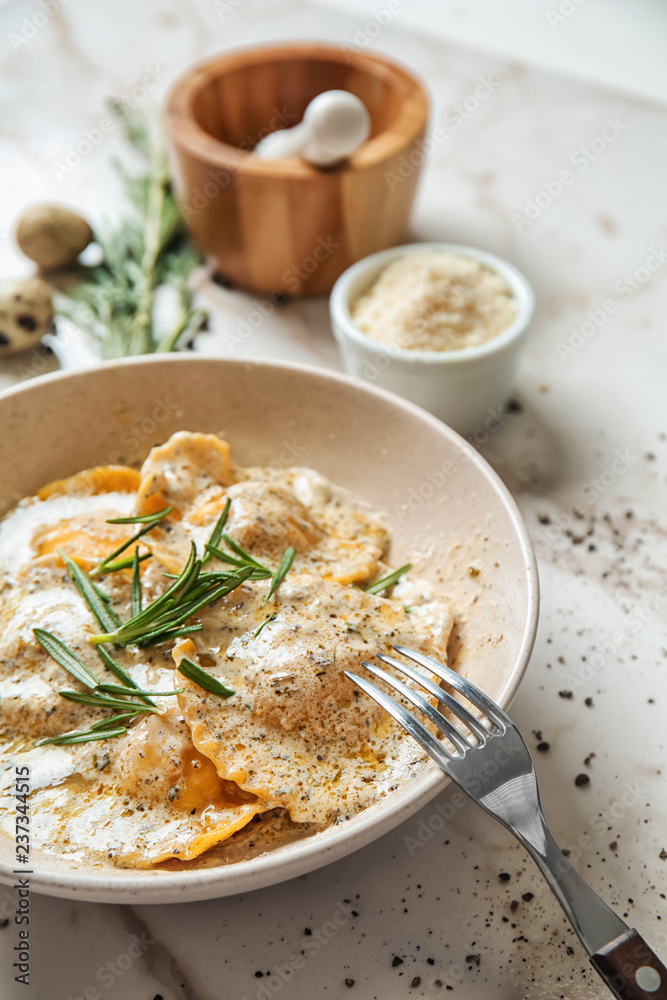 Plate with tasty ravioli on marble table