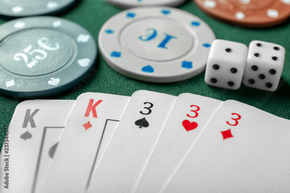 Chips with cards and dices for poker game on green table in casino Chips with cards and dices for poker game on green table in casino