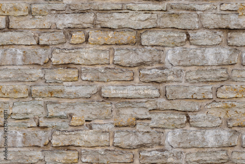 Fragment of old gray brick stone wall background, seamless tiling texture