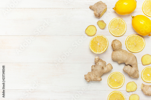 Fresh ginger root and lemon on white wooden background. Flat lay, top view, copy space. Minimalistic style, seasoning, spice, ingredient for tea. Concept healthy food, medicine, improving immunity