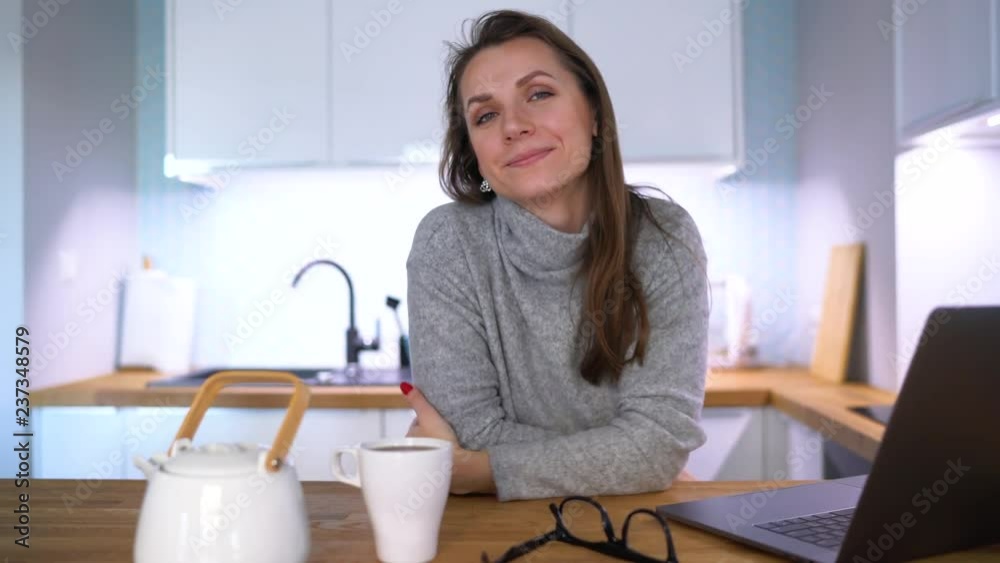 Portrait of caucasian woman who has breakfast in the kitchen and using a laptop Portrait of caucasian woman who has breakfast in the kitchen and using a laptop
