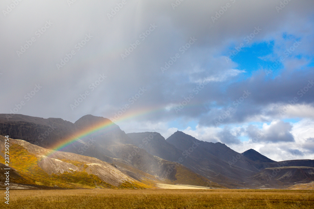 A look from Iceland, when rain falls, a rainbow forms. In the background is the volcanic mountain range.