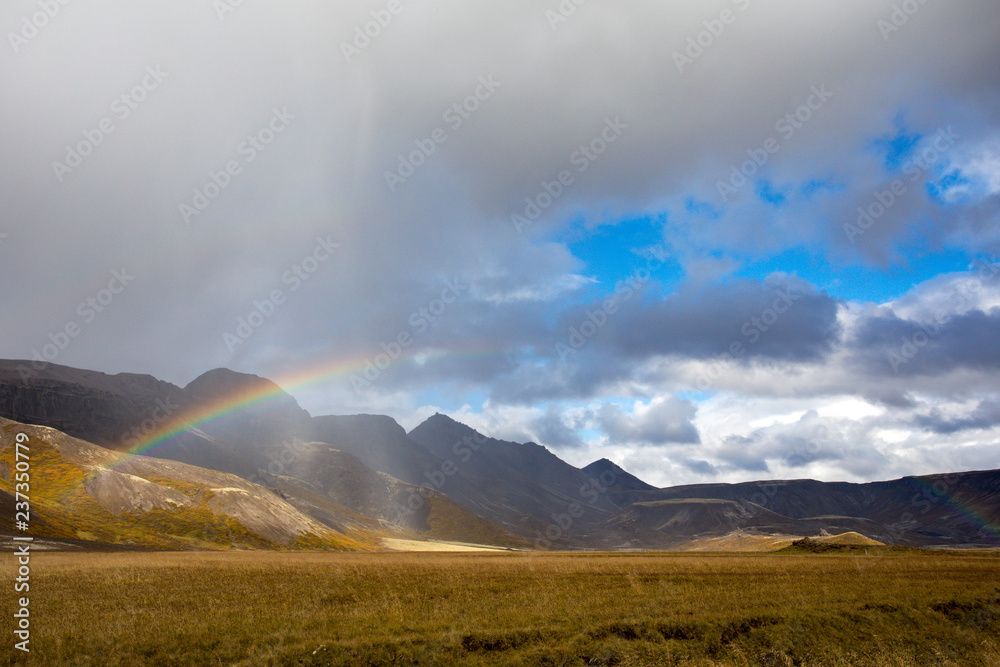 A look from Iceland, when rain falls, a rainbow forms. In the background is the volcanic mountain range.