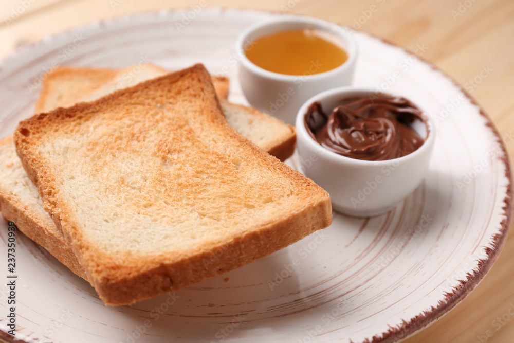 Tasty toasted bread with chocolate sauce and honey on plate Tasty toasted bread with chocolate sauce and honey on plate