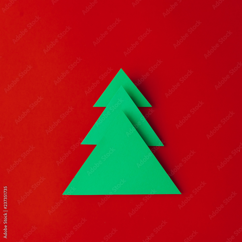 Minimal paper art Christmas tree on red background. Flat lay. New Year concept. Minimal paper art Christmas tree on red background. Flat lay. New Year concept.