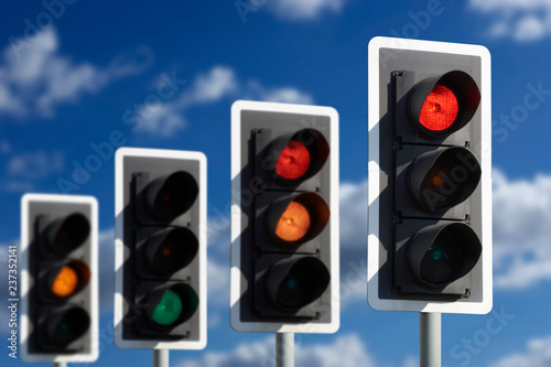 ROW OF FOUR ROAD TRAFFIC LIGHTS SHOWING SEQUENCE OF RED RED AND AMBER GREEN AND AMBER