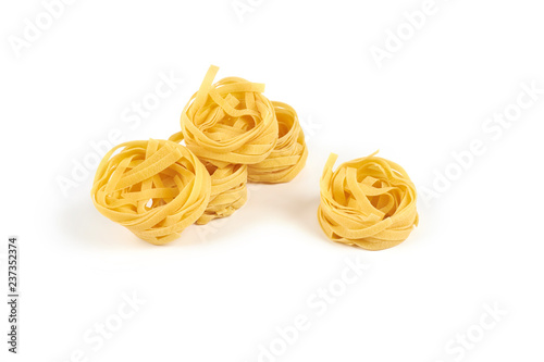 Uncooked nest of tagliatelle pasta isolated on white background.