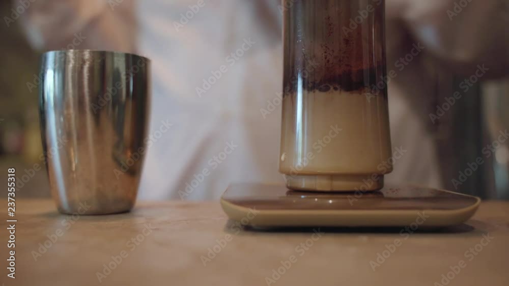 Measuring drink ingredients in blender bottle at café