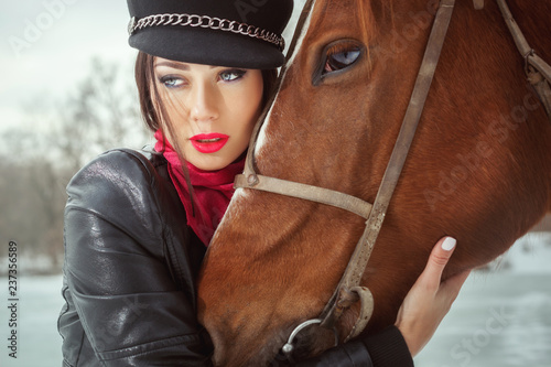 Woman's face and the horse's head are close-up with sad eyes.