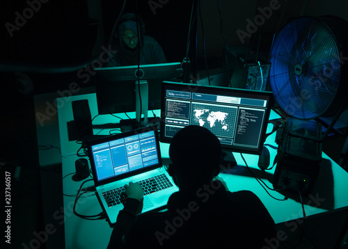 Wanted hackers coding virus ransomware using laptops and computers. Cyber attack, system breaking and malware concept.