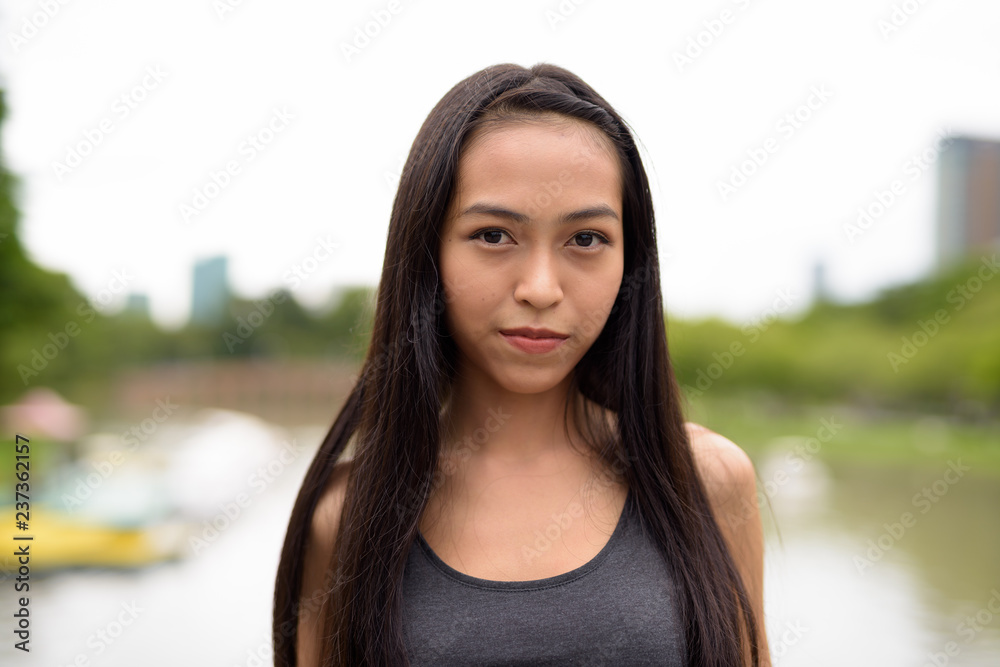 Young beautiful Asian woman relaxing at the park Young beautiful Asian woman relaxing at the park