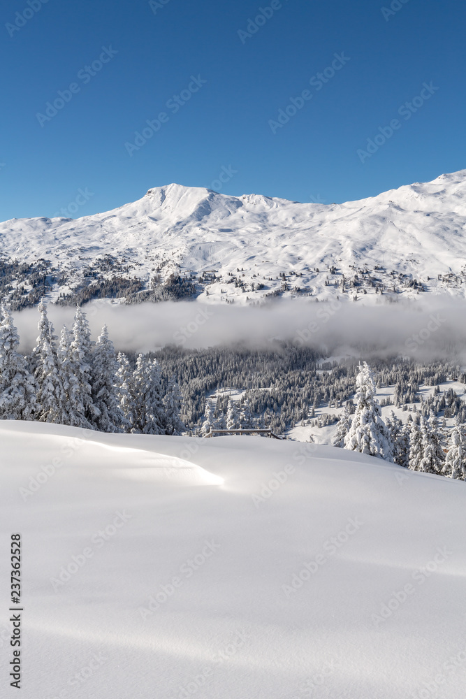 Verschneite Winterlandschaft mit Weitsicht auf die Alpen und aufkommenden Nebel - Parpaner Rothorn, Graubünden, Schweiz