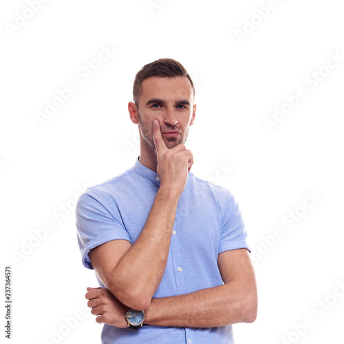 Casually handsome. Confident young handsome man in jeans shirt keeping arms crossed and smiling while standing against white background