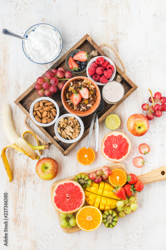 Top view of paleo grain free nut and fruit granola served with fruits and berries, nut milk, vertical, top view, selective focus