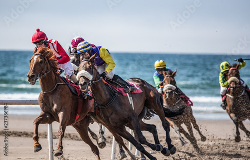 Horse racing action on the beach, lead horses competing for position on the turn of the track