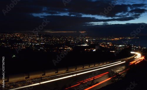 Vue generale de Beyrouth la nuit avec une route et les feux des voitures en mouvement au premier plan photo