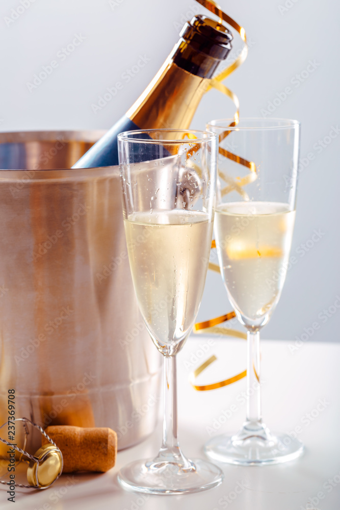 Fototapeta Parę kieliszka szampana z butelką w metalowym pojemniku. Obchody nowego roku