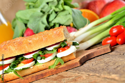 Bread sandwich with egg, arugula salad, tomatoes and radish photo