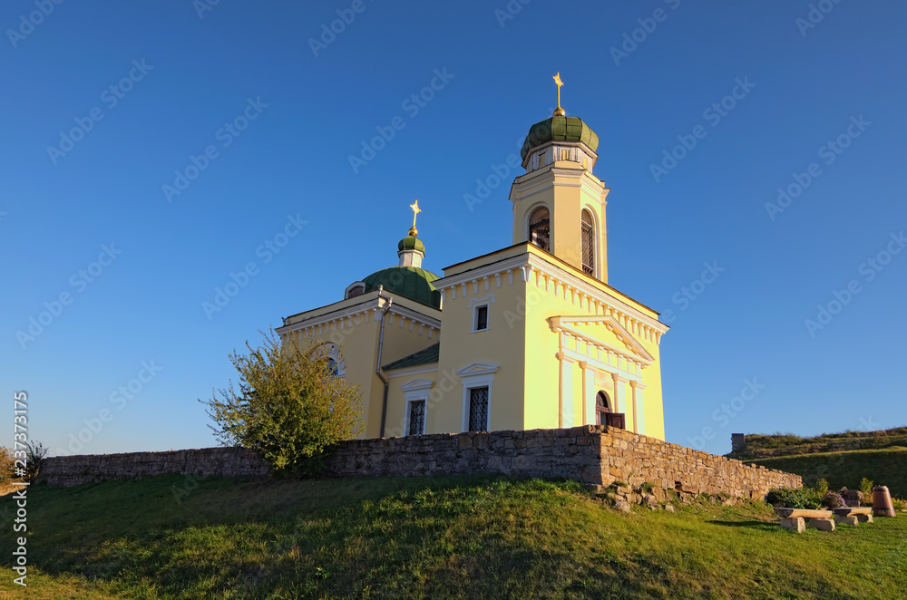 The Saint Alexander Nevsky Church against blue sky near Khotyn Fortress. Autumn landscape view.   Famous touristic place and travel destination in Ukraine. Khotyn. Chernivtsi region. Ukraine