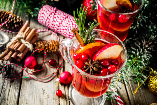 Traditional Christmas Mulled wine, grog or hot spicy sangria cocktail, on old rustic wooden table with christmas decorations and fir tree branches copy space top view
