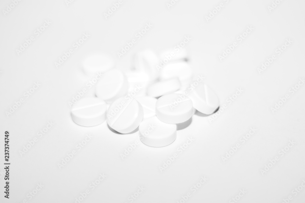 White pills on white background. Close-up view. Medical background. Healthcare image. White pills on white background. Close-up view. Medical background. Healthcare image.