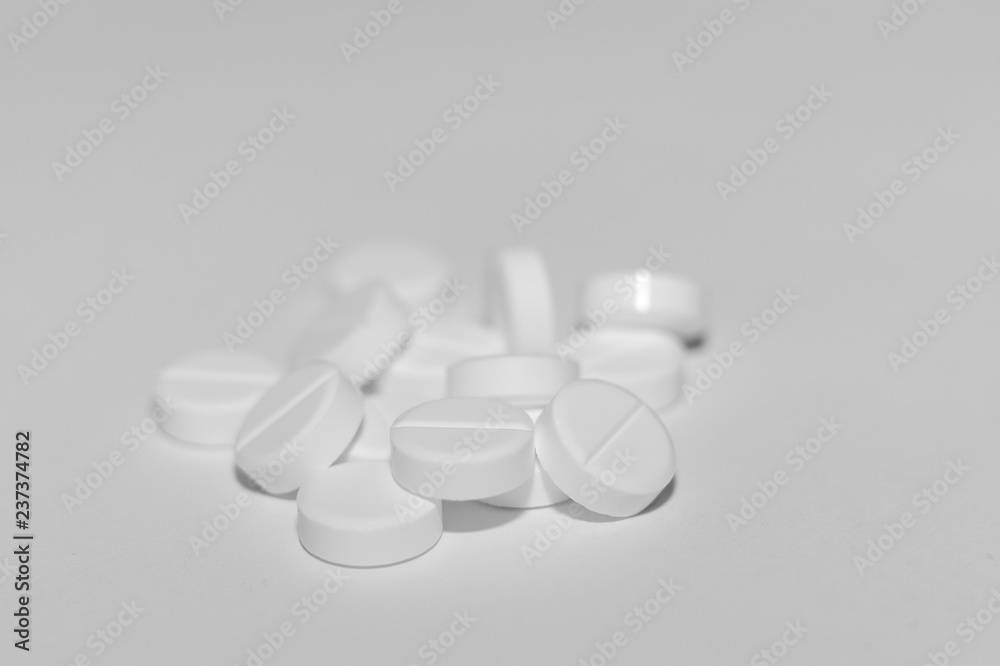 White pills on white background. Close-up view. Medical background. Healthcare image.