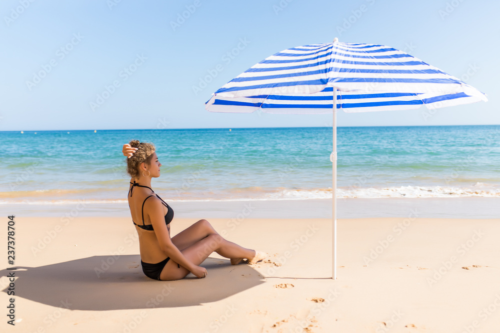 Beautiful sexual girl lying on the sand pose on beach in bikini on sea background Beautiful sexual girl lying on the sand pose on beach in bikini on sea background