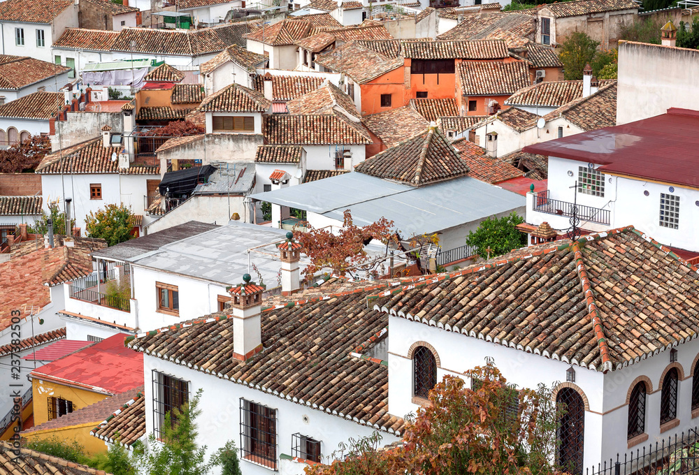 Tile roofs of old houses on cityscape of Granada. Landscape of historical town of Andalusia, Spain