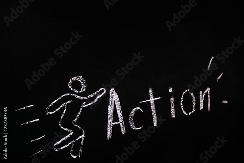 drawn in chalk on a black blackboard the symbol of the running man and the word action